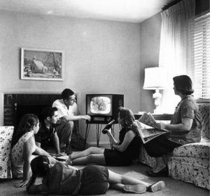 A family gathering together to all watch T.V. in 1958